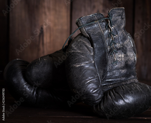 pair of very old shabby black leather boxing gloves © nndanko