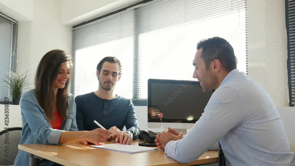 young couple buying agreement contract signature and hand shaking with professional finance business man in office