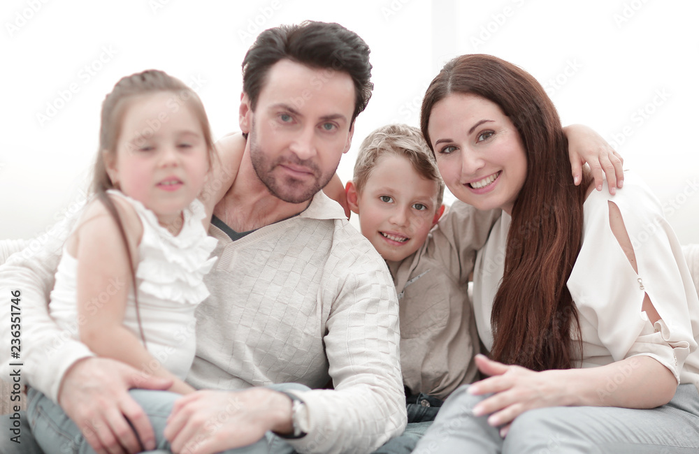 parents hug their children sitting on the couch