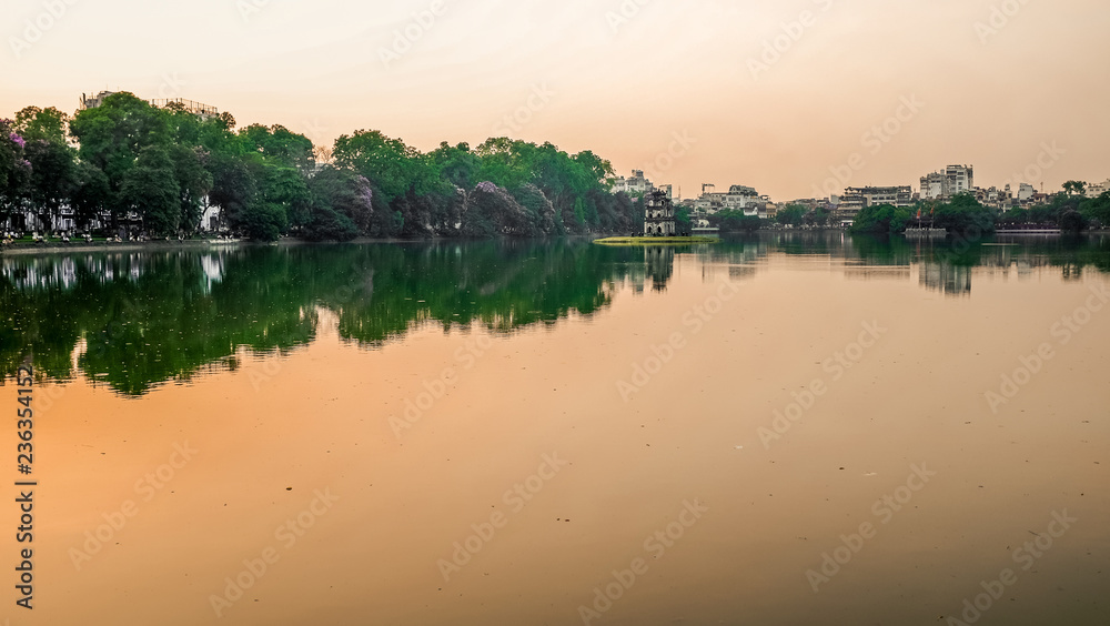 The sun setting over a lake in Hanoi, Vietnam
