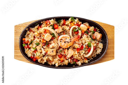 Top view pan of traditional Japanese rice with vegetables and seafood at wooden board isolated at white background.