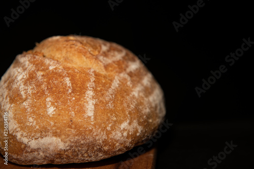 Крупная белая булка хлеба на черном фоне