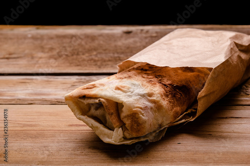 Shawarma sandwich gyro fresh roll of lavash pita bread chicken beef shawarma falafel RecipeTin Eatsfilled with grilled meat  mushrooms  cheese. Traditional Middle Eastern snack. On wooden background