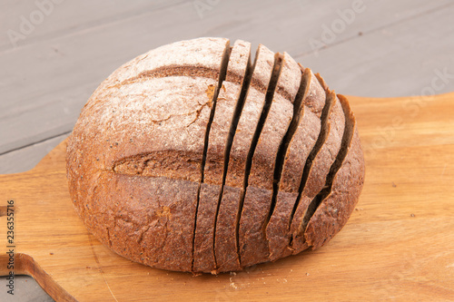 Нарезанная булка черного хлеба на доске