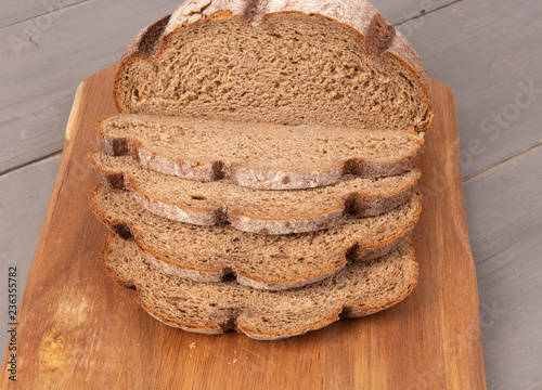 Нарезанная буханка черного хлеба на доске