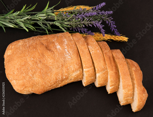 Нарезанная чиабатта на черном фоне с колосками