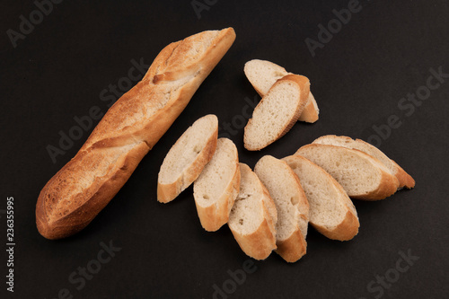 Нарезанный французский багет на черном фоне