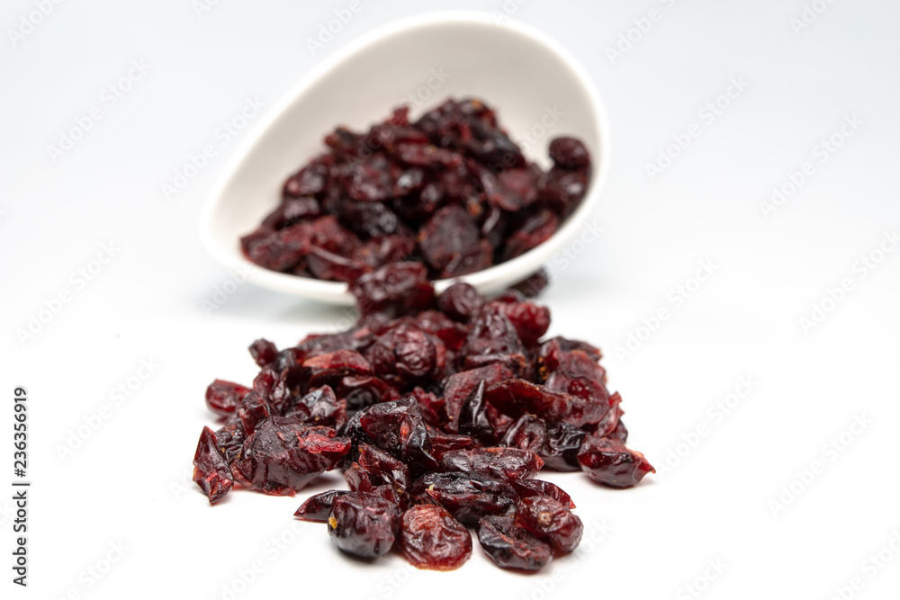 Tasty dried cranberries in a white bowl. Treats for cakes on the kitchen table. Tasty dried cranberries in a white bowl. Treats for cakes on the kitchen table.