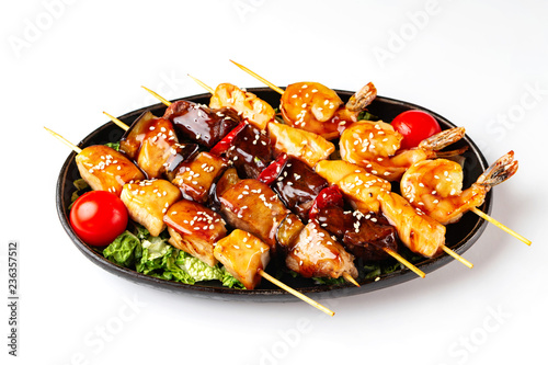 Closeup plate of grilled barbeque set of beef, porkm chicken, salmon and shrimps sticks isolated at white background. photo