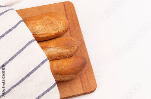 Французские багеты на доске под полотенцем