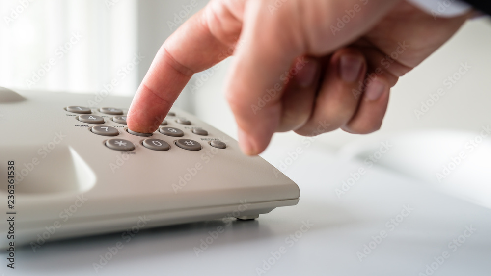 Low angle closeup view of male hand dialing a phone number Low angle closeup view of male hand dialing a phone number