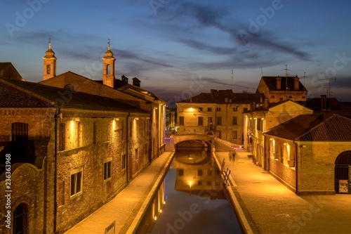 View from the Trepponti bridge on canal with village at dusk, Comacchio, Emilia-Romagna, Italy, Europe photo
