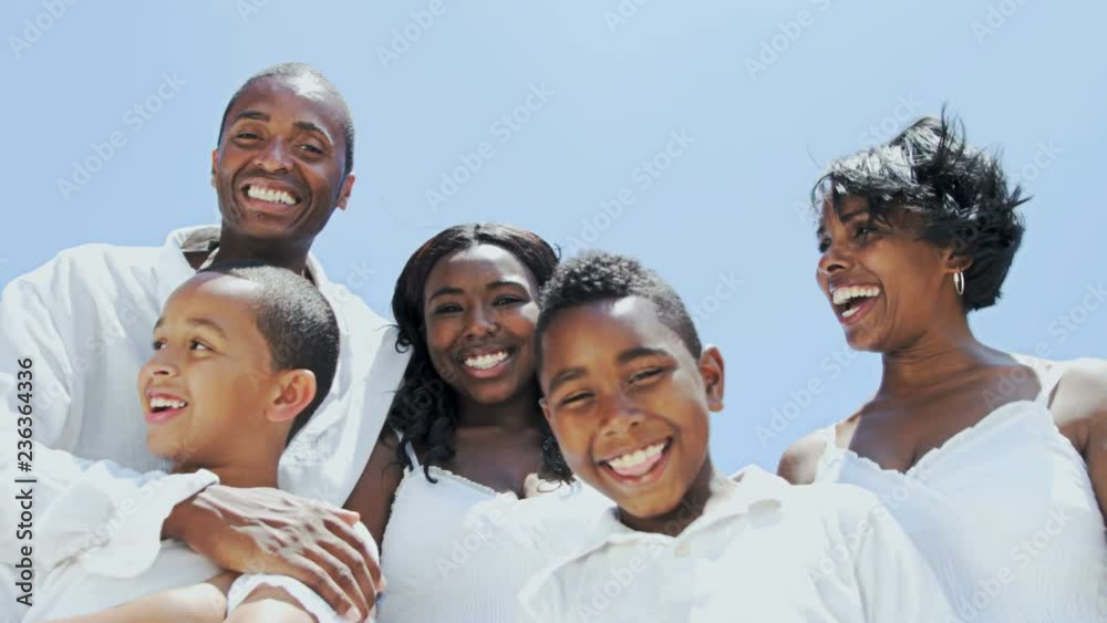 Portrait of happy African American family making video diary on their beach holiday RED EPIC