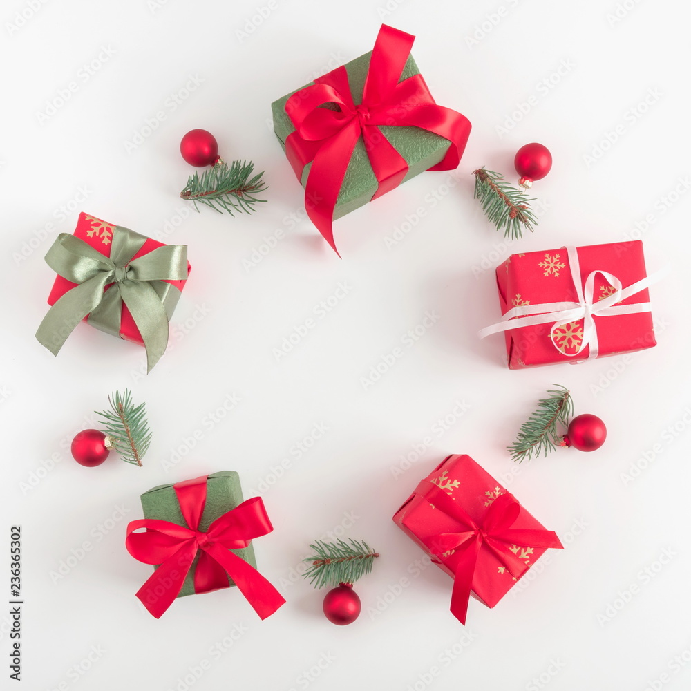 Christmas cozy composition. Wreath made of gifts, fir tree branches, red decorations on white background. Christmas, New Year, winter concept. Flat lay, top view, copy space, square Christmas cozy composition. Wreath made of gifts, fir tree branches, red decorations on white background. Christmas, New Year, winter concept. Flat lay, top view, copy space, square