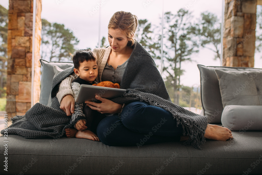 Obraz premium Mother and son with digital tablet in the living room