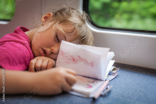 Little girl asleep inside the train carriage photo