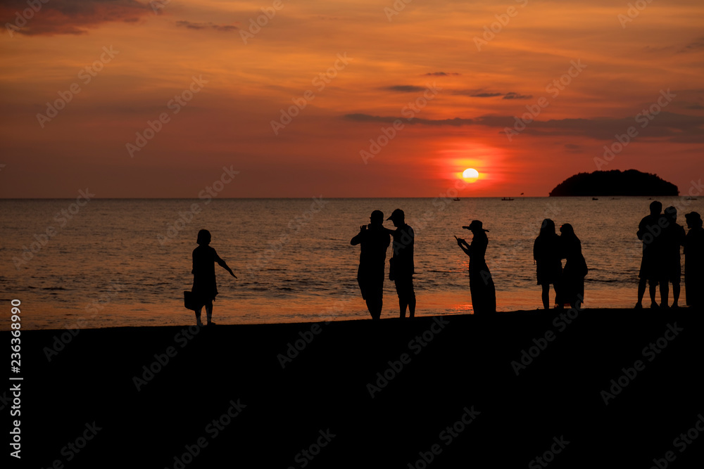 Silhouette of people visiting the Tanjung Aru beach during sunset located in Kota Kinabalu, Sabah, Malaysia.