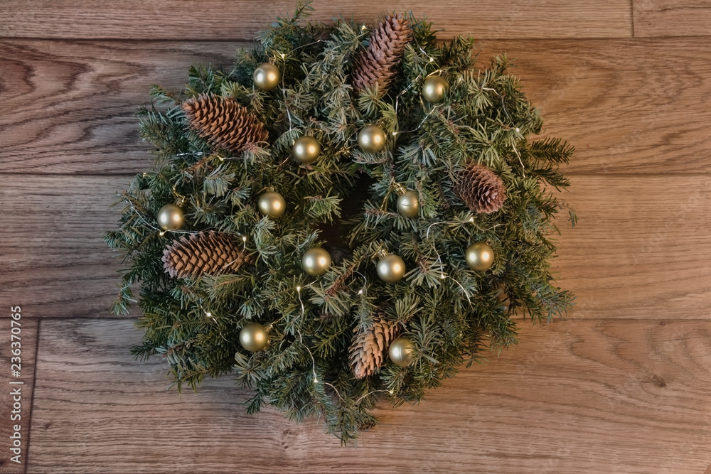 a wreath of fir branches with cones, lights garlands and golden balls. a wreath of fir branches with cones, lights garlands and golden balls.