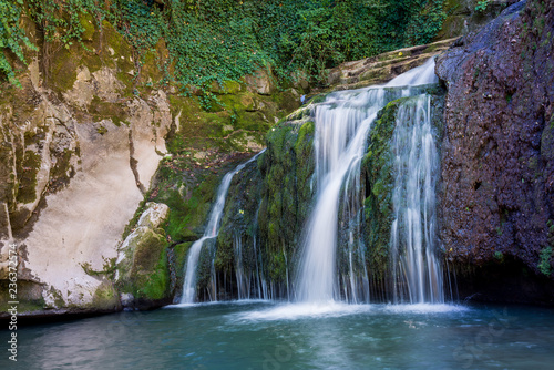 Fototapeta Naklejka Na Ścianę i Meble -  Beautiful stream waterfalls cascade over pretty green moss covered stones
