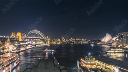 Buzzing Sydney Harbour at night with the iconic Sydney Opera House and spectacular Sydney Harbour Bridge.