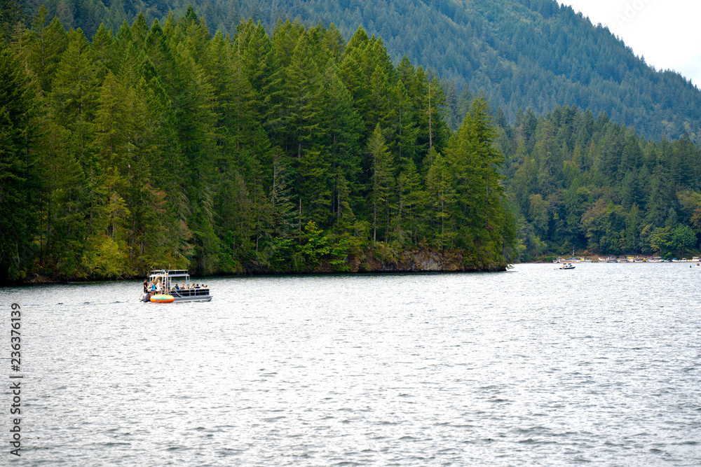 Boat ride through the picturesque clear mountain Merwin Lake with mountain forest banks