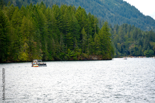 Boat ride through the picturesque clear mountain Merwin Lake with mountain forest banks