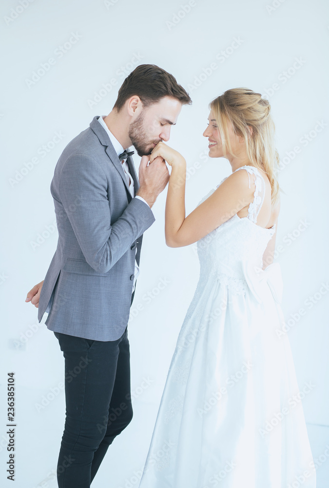 Portrait of groom with bride kissing in her hand on white background,Happy and smiling in engagement day Portrait of groom with bride kissing in her hand on white background,Happy and smiling in engagement day
