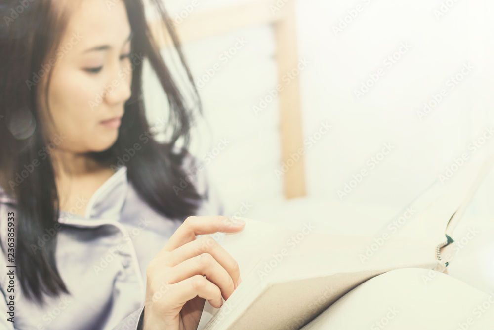 women read book to learning on bed in bed room in the morning.color tone women read book to learning on bed in bed room in the morning.color tone