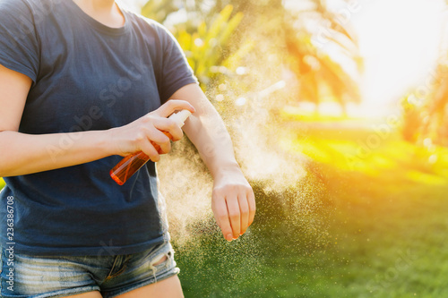 Woman applying insect repellent before forest hike beautiful summer day.