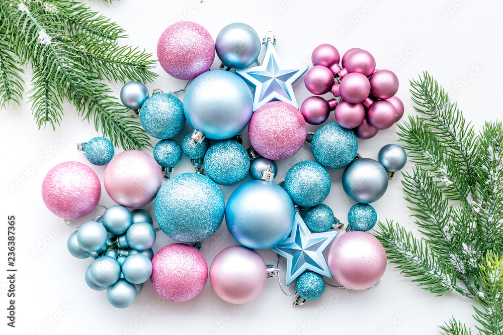 New Year and Christmas atmosphere. Decorate festive christmas tree. Christmas tree decoration. Blue and pink balls and stars near spruce branch, pine fir on white background top view New Year and Christmas atmosphere. Decorate festive christmas tree. Christmas tree decoration. Blue and pink balls and stars near spruce branch, pine fir on white background top view