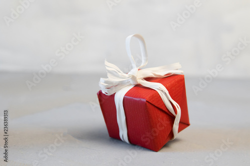 Christmas gifts presents on red background. Simple, classic, red and white wrapped gift boxes with ribbon bows and festive holiday decorations.