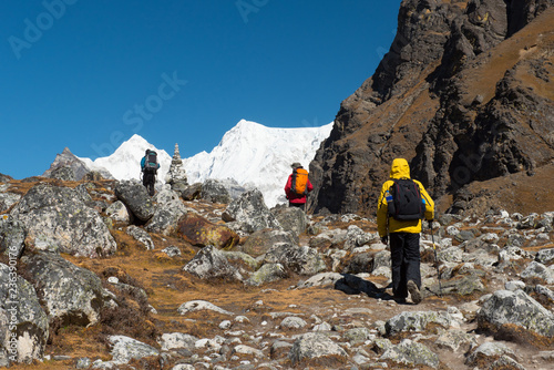 trekker walk on tie way to Renjora pass with everest mountain peak and stone stack in background,travel Nepal concept photo