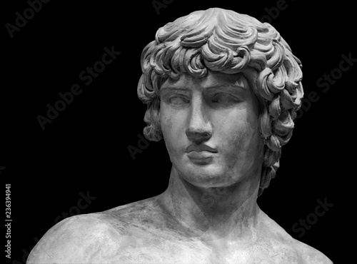 Head and shoulders detail of the ancient sculpture. Isolated on black background
