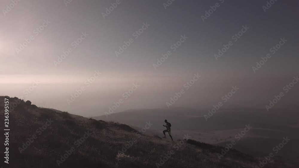 man is running in mountains in sunset