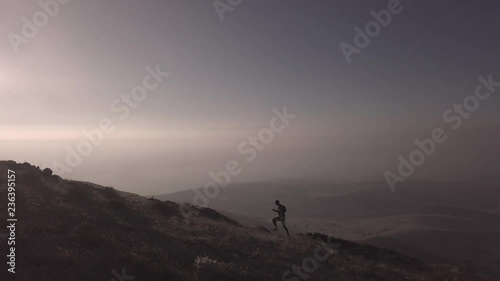 man is running in mountains in sunset