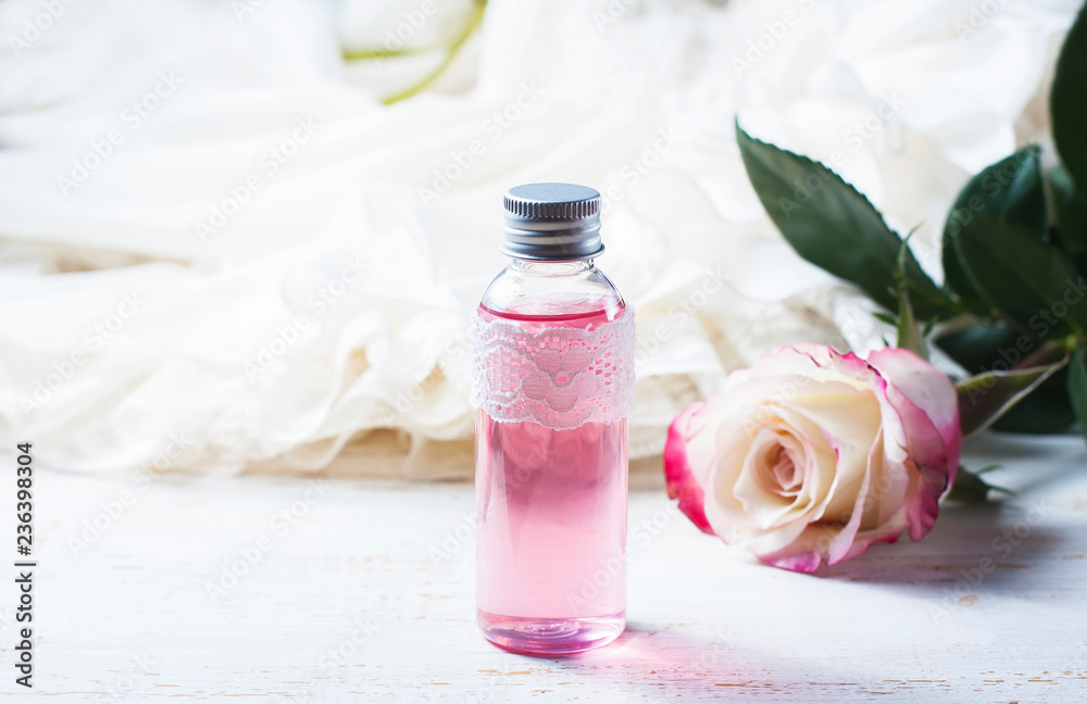 perfumed rose water in a bottle on a wooden table perfumed rose water in a bottle on a wooden table