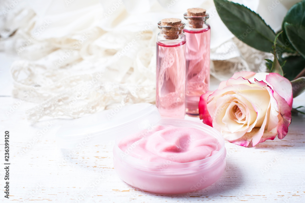 cosmetic cream with pink roses on a wooden table cosmetic cream with pink roses on a wooden table