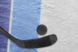Hockey stick, puck and fragment of the ice arena with blue lines