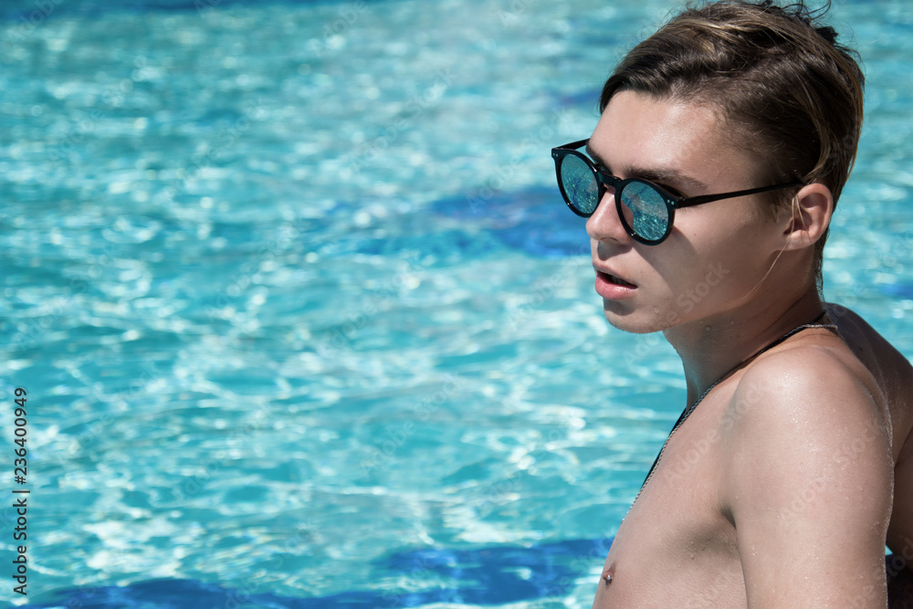 Young attractive guy. Summer, relaxation and pool.  