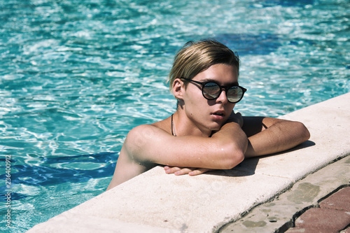 Young attractive guy. Summer, relaxation and pool.   © vladorlov