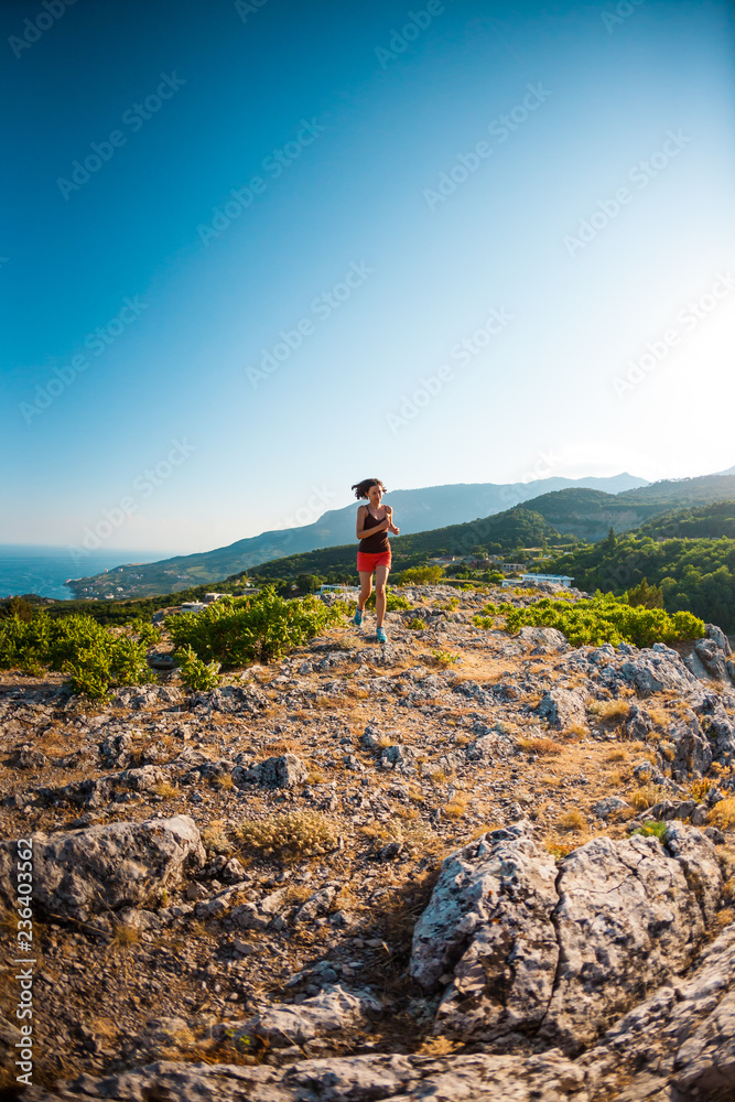 A girl is running in the mountains.