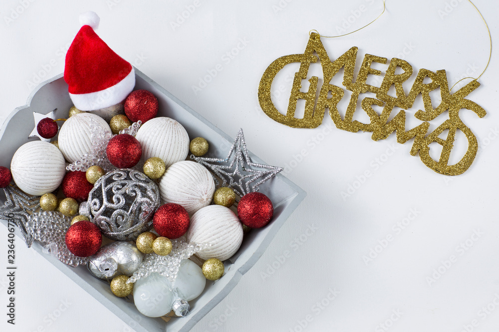 Christmas decorations in the wooden gray tray: balls, hearts, stars, Santa Claus hat and written in gold letters Merry Christmas Christmas decorations in the wooden gray tray: balls, hearts, stars, Santa Claus hat and written in gold letters Merry Christmas