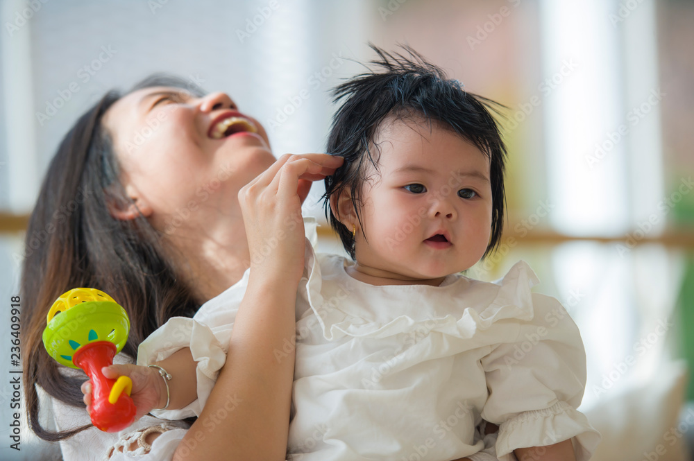 young happy beautiful Asian Korean woman playing with baby girl sitting at holidays resort enjoying vacation trip in mother and little daughter love young happy beautiful Asian Korean woman playing with baby girl sitting at holidays resort enjoying vacation trip in mother and little daughter love