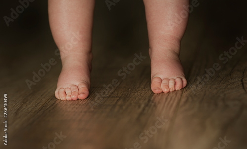 legs of newborn baby close up on isolated wooden background