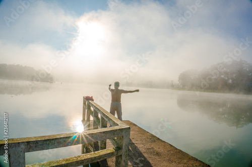 anonymous man doing morning exercise on a bridge at Xuan Huong lake- Da Lat
 photo