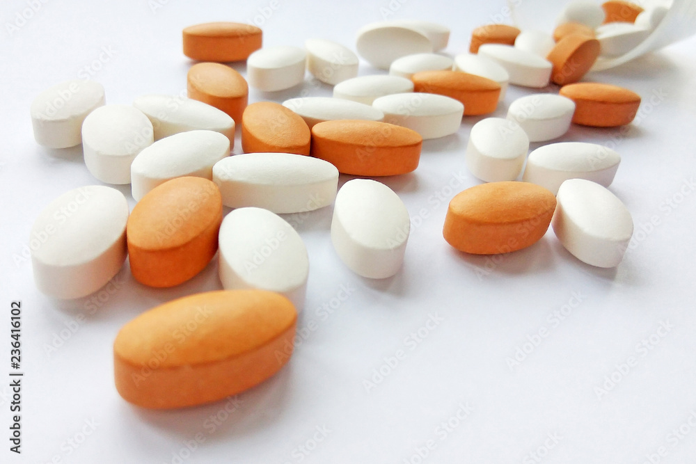 Spilling colorful pharmaceutical medicine pills, tablets and capsules in jar on white background. Pharmacy theme, health care, drug prescription for treatment medication and pharmaceutical medicament Spilling colorful pharmaceutical medicine pills, tablets and capsules in jar on white background. Pharmacy theme, health care, drug prescription for treatment medication and pharmaceutical medicament