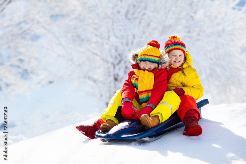 Kids play in snow. Winter sleigh ride for children