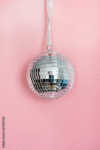 Christmas silver disco ball hanging on pink. Creative Xmas pattern.