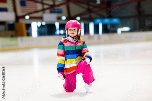 Child skating on indoor ice rink. Kids skate.