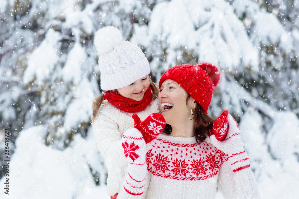 Mother and child in knitted winter hats in snow. Mother and child in knitted winter hats in snow.